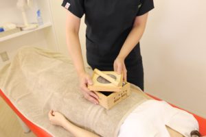 鍼灸施術でます灸をお腹の上に置いている写真です。